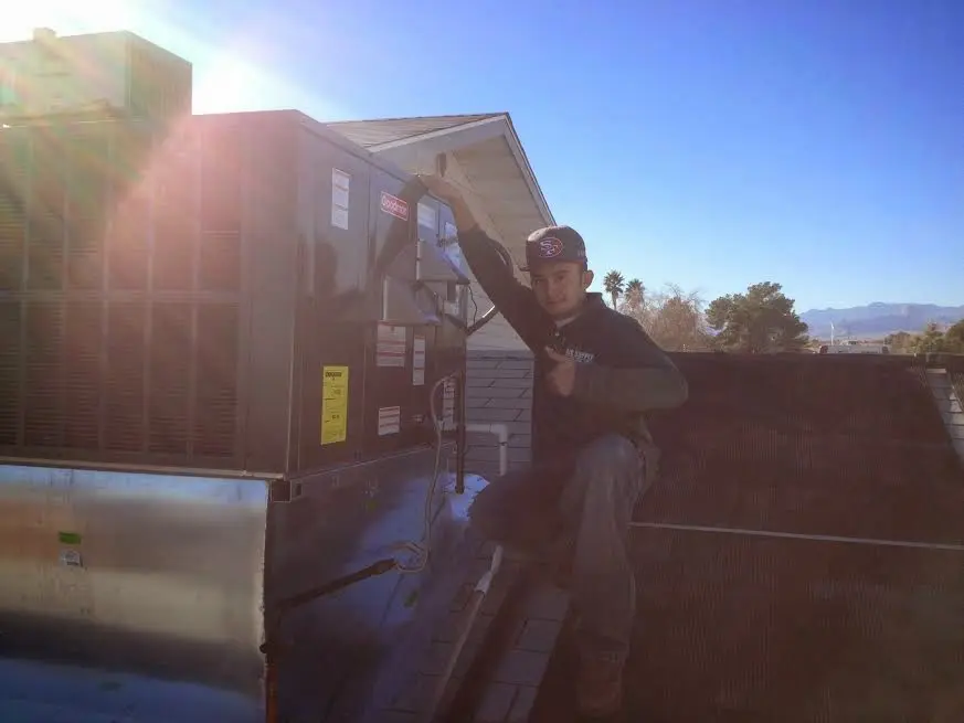 HVAC technician performing Air Duct Cleaning on a rooftop unit in Dundee